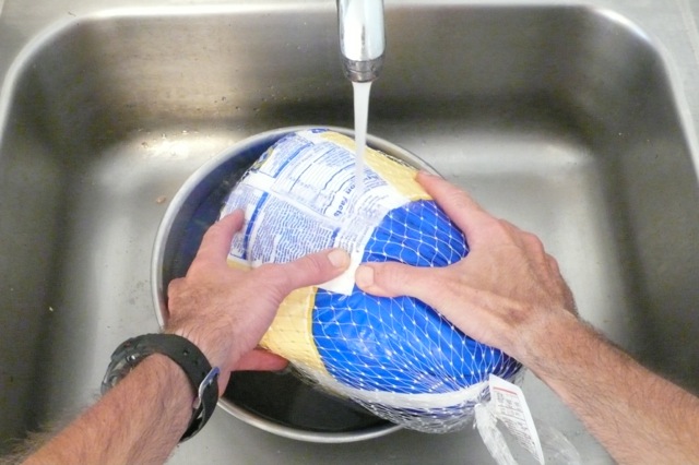 Turning the turkey every 30 minutes to improve even thawing