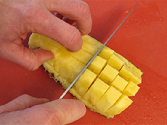 Quartering fresh pineapple with step-by-step photo directions showing how to ripen and cut fresh pineapple.