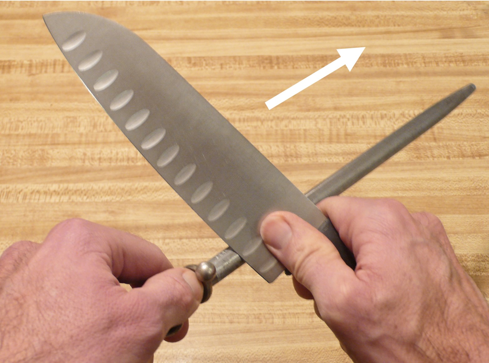 Image showing how to sharpen a knife safely with a sharpening steel.,